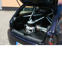 Ein abgedecktes Bassreflexgehäuse im Kofferraum eines blauen Opels