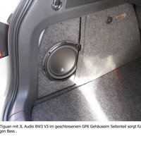 Ein abgedecktes Bassreflexgehäuse im Kofferraum eines Volkswagens