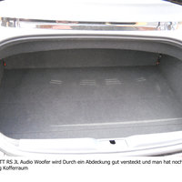 Ein abgedecktes Bassreflexgehäuse im Kofferraum eines Audis