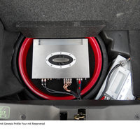 Ein abgedeckter Verstärker im Kofferraum eines schwarzen Porsches