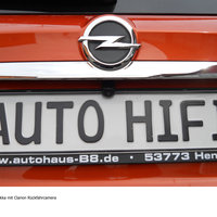 Eine Rückfahrkamera über dem Nummernschild eines orangen Opels